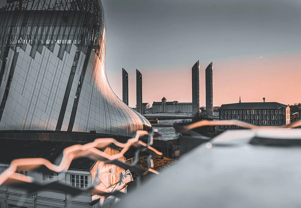 Façade architecturale moderne de la Cité du Vin à Bordeaux, avec ses courbes distinctives, au bord de la Garonne.